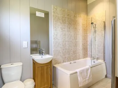 a bathroom with a tub and a sink and a toilet at Skylarks in Hengrave