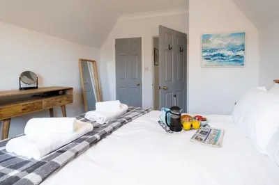 a bedroom with two beds with towels and fruit on them at 15 Mill Field - Aldeburgh Coastal Cottages in Aldeburgh