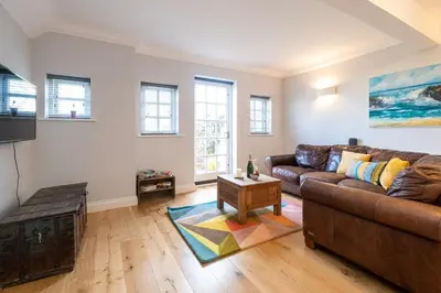 a living room with a couch and a table at 15 Mill Field - Aldeburgh Coastal Cottages in Aldeburgh