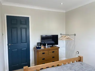 a bedroom with a blue door and a television on a dresser at Executive home with plenty of room in Ely
