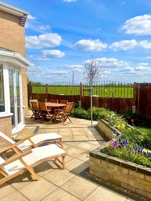 a patio with a table and chairs and a fence at Executive home with plenty of room in Ely