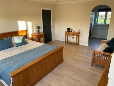 a bedroom with a large bed and a chair at Executive home with plenty of room in Ely