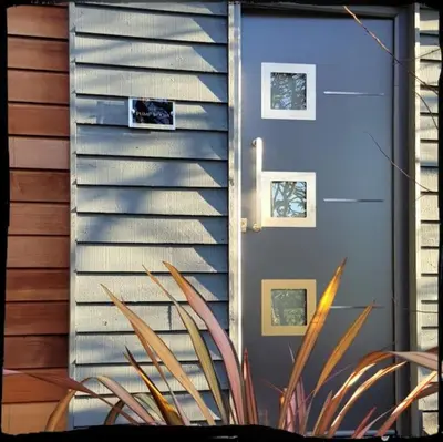 a house with a blue door and a plant at Lauriston Stay in Birch