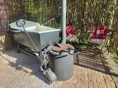 a trash can next to a trashcan with a wheelbarrow at Stompy's Hut in Laxfield
