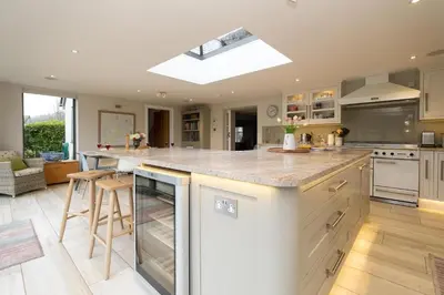 a kitchen with a large island with a counter top at White Cottage, Iken - Aldeburgh Coastal Cottages in Snape