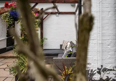 a couch sitting on a bench in a garden at 3 Bed in Letheringham oc-pclet in Kettleburgh