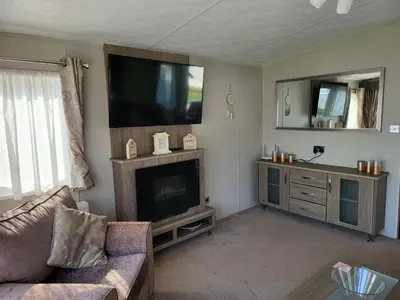 a living room with a flat screen tv and a couch at 2BR-Sleeps6-Fireplace-Parking-Patio-Seaside in Clacton-on-Sea