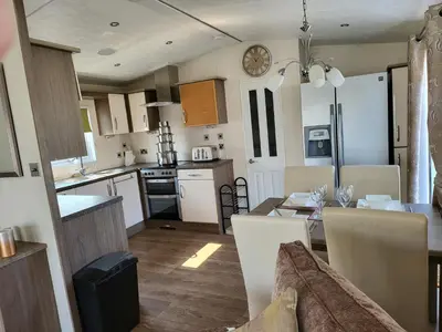 a kitchen and dining room with a table and a dining room at 2BR-Sleeps6-Fireplace-Parking-Patio-Seaside in Clacton-on-Sea