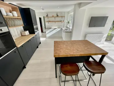 a kitchen with a table and two stools at Island House in West Mersea