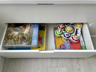 a white drawer filled with toys and magazines at Island House in West Mersea