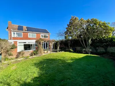 a house with a large lawn in front of it at Island House in West Mersea