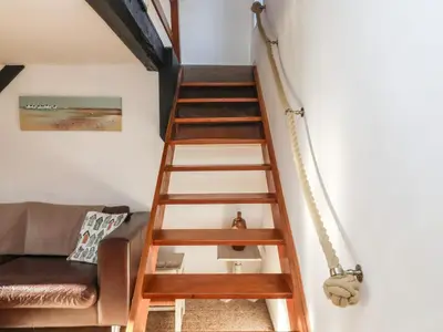 a wooden staircase in a living room with a couch at 2 Greensleeves in Saxmundham