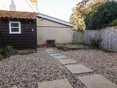 a backyard with a stone path next to a house at 2 Greensleeves in Saxmundham