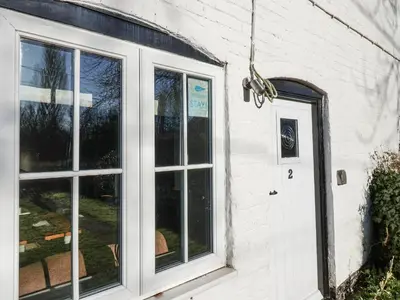 a white building with a window and a door at 2 Greensleeves in Saxmundham