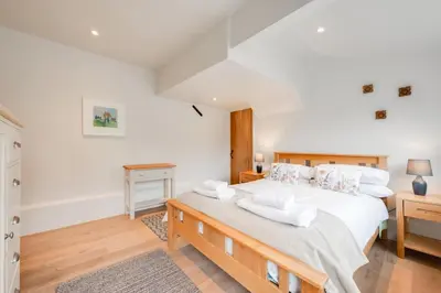 a bedroom with a large bed with white sheets and pillows at 4 Bed in Westleton oc-holc in Westleton