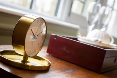 a gold clock sitting on top of a table at Worlington Hall in Worlington
