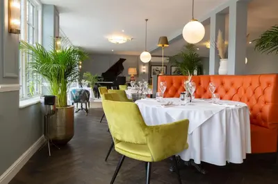 a dining room with a white table and yellow chairs at Worlington Hall in Worlington