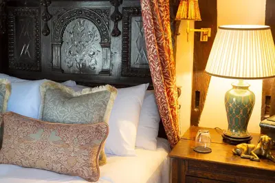 a bedroom with a bed and a lamp on a table at Worlington Hall in Worlington