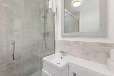 a bathroom with a shower and a sink and a mirror at Skyvillion - STEVENAGE SPACIOUS & COZY 3Bed House with Parking, Wifi, Garden in Aston End