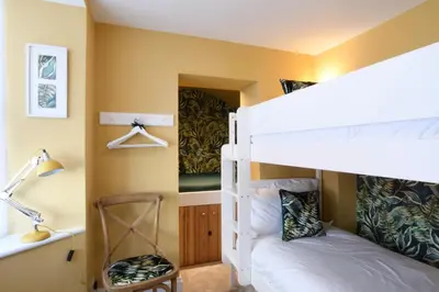 a bedroom with two bunk beds and a desk at Cragside, Aldeburgh in Aldeburgh