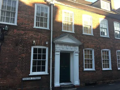 a brick building with a door and a street sign at Elizabeth Clark in Manningtree