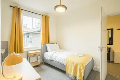 a small bedroom with a bed and a window at Fabulous Large Apartment for 7 - CENTRAL Cambridge in Cambridge
