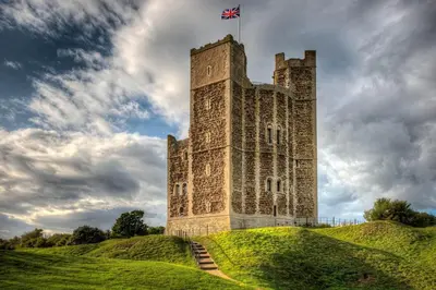 a castle with a flag on top of a hill at The Coach House Barn - Valley Farm in Sudbourne