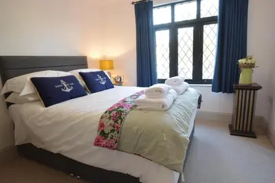 a bedroom with a bed with towels on it at Badminton, Thorpeness in Thorpeness