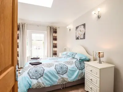a bedroom with a blue and white bed and a window at 493 Little Wakering Road in Southend-on-Sea