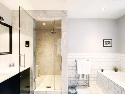 a bathroom with a shower and a tub and a sink at Spring House by The Suffolk Cottage Collection in Aldeburgh
