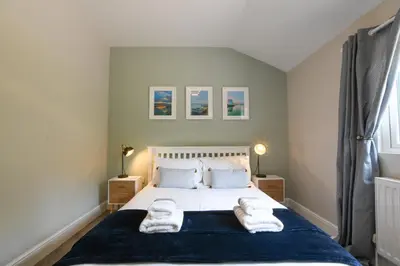 a bedroom with a bed with towels on it at The Piglets in Woodbridge