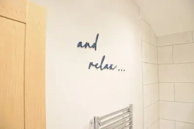 a bathroom with a sign that says and raala on the wall at The Piglets in Woodbridge