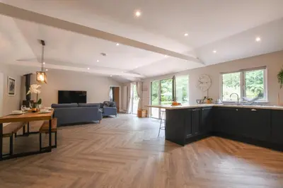 a kitchen and living room with a couch and a table at The Piglets in Woodbridge