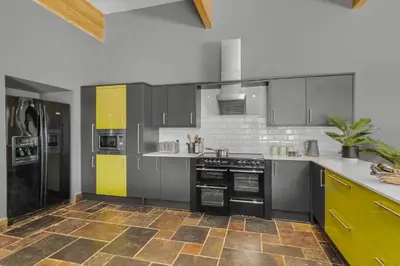 a kitchen with gray cabinets and yellow accents at 4 Bedroom House in Larling, near Thetford in Snetterton