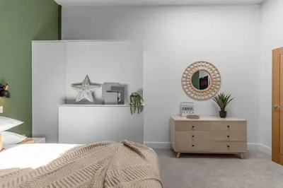 a bedroom with a bed and a mirror and a dresser at 4 Bedroom House in Larling, near Thetford in Snetterton
