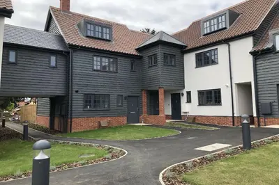 a house with a driveway in front of it at Corner Cottage, Thorpeness in Thorpeness