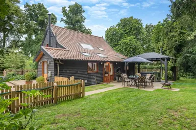 a small house with a wooden fence and a patio at 3 Bed in Ketteringham oc-1878 in East Carleton