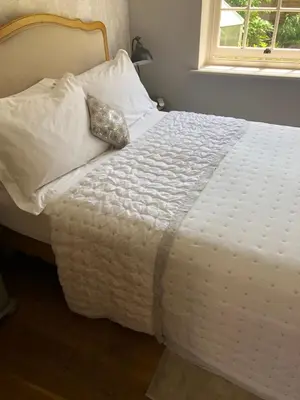 a white bed with a pillow on top of it at Glanthams Lodge Guestroom in Shenfield