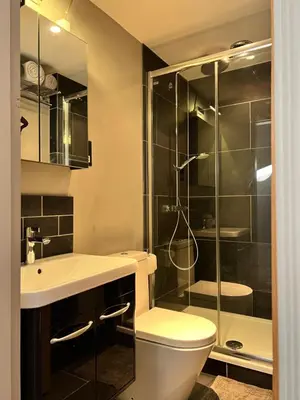 a bathroom with a toilet and a glass shower at Glanthams Lodge Guestroom in Shenfield