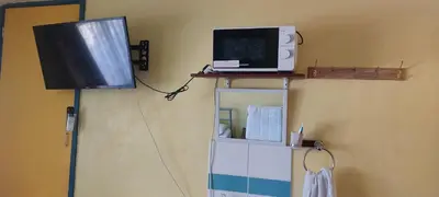 a television sitting on a shelf with a microwave at Basildon House of Muralist in Basildon
