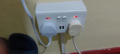 a white electrical outlet with a cord plugged into it at Basildon House of Muralist in Basildon