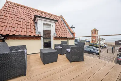 a balcony with wicker chairs on a wooden deck at Guild House, Aldeburgh in Aldeburgh