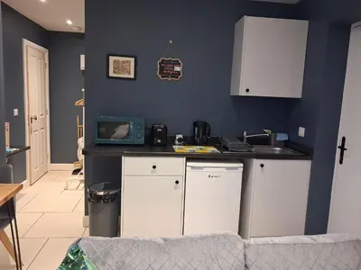 a kitchen with white cabinets and a blue wall at Suite near City, Science Park & Marshalls and close to Riverside walks in Milton