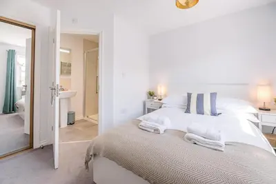 a white bedroom with a bed and a bathroom at Alde Seagull, Aldeburgh in Aldeburgh