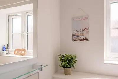 a white bathroom with a potted plant on a counter at Alde Seagull, Aldeburgh in Aldeburgh