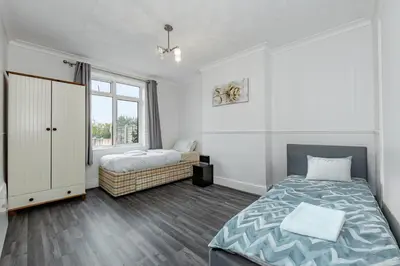 a bedroom with two beds and a window at The Comfy Contractors Resort, Free Private Parking & Wifi, 7 beds in Colchester