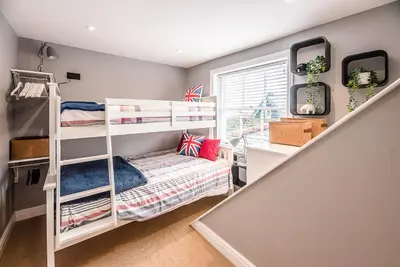 a bedroom with two bunk beds and a staircase at The Picture House, Aldeburgh in Aldeburgh