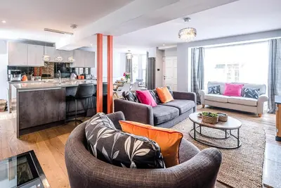 a living room with two couches and a kitchen at The Picture House, Aldeburgh in Aldeburgh
