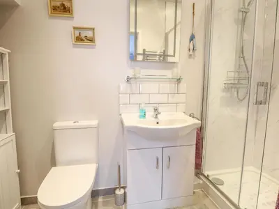 a bathroom with a toilet and a sink and a shower at Jimmys Place in Diss
