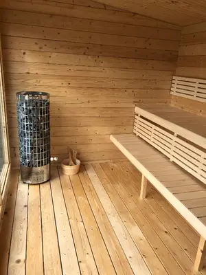 a sauna with a bench and a trash can at The Kestrel Shepherd Hut, Whitehouse Farm in Stowmarket